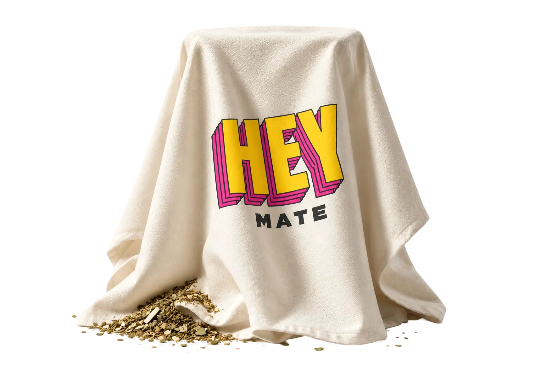 A draped cloth printed with the Hey Mate logo, loose yerba mate spilling from underneath